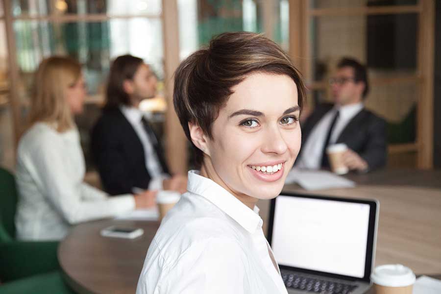 Woman at a meeting smiling directly at the camera