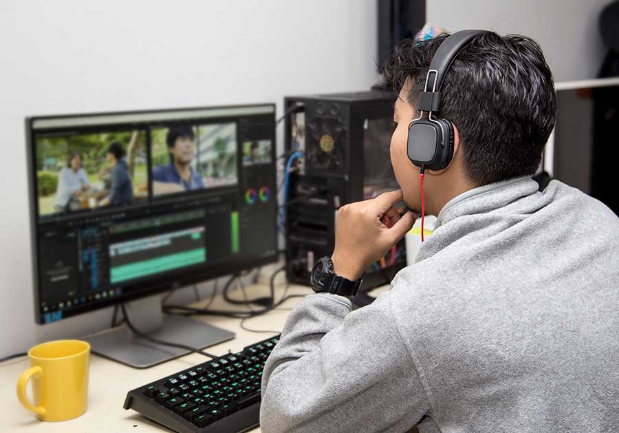 Man working on computer with video editing software