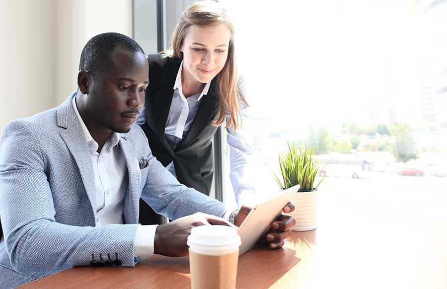 African male and woman looking at laptop