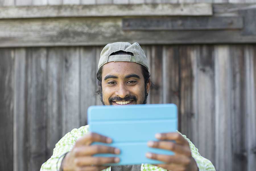 Indian man on an ipad smiling