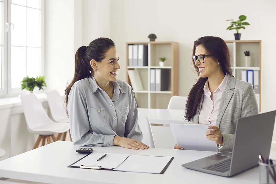 Two women having a friendly discussion at an office