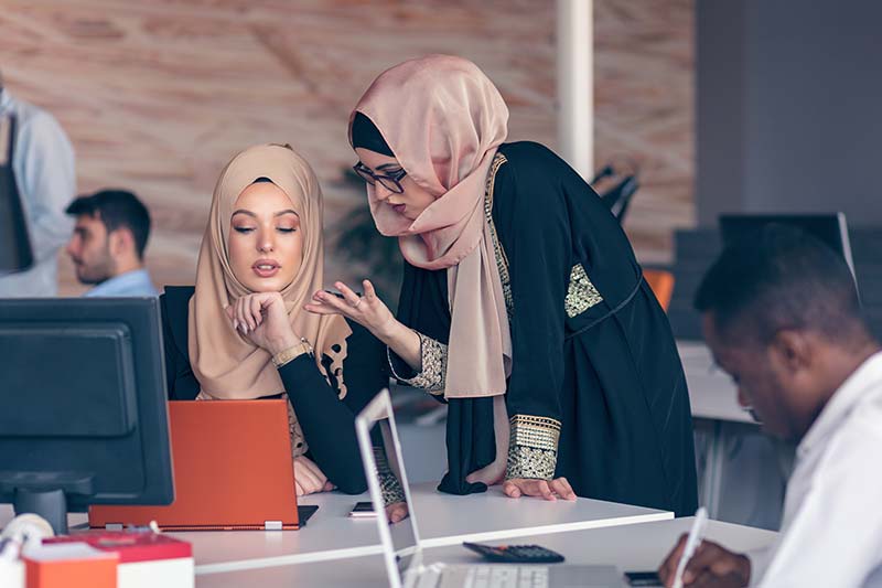 Two female Arabic translators working with language technology 