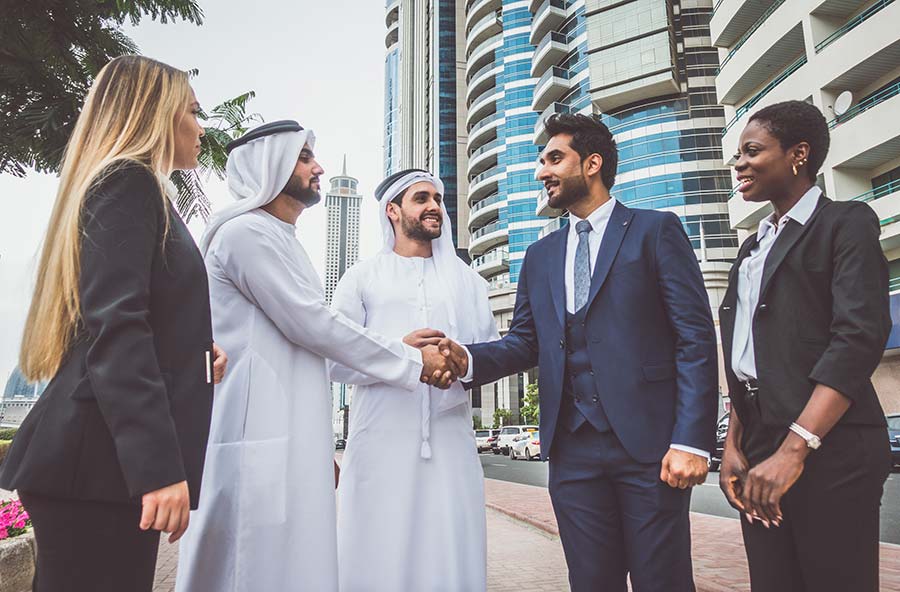 Un groupe de traducteurs arabes serrant la main à des clients.