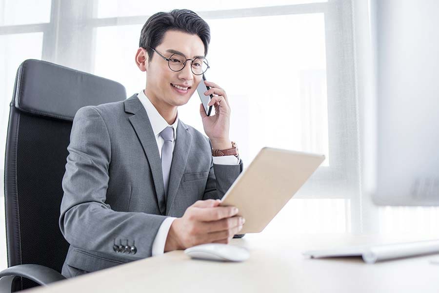 Chinese businessman on phone and laptop in office