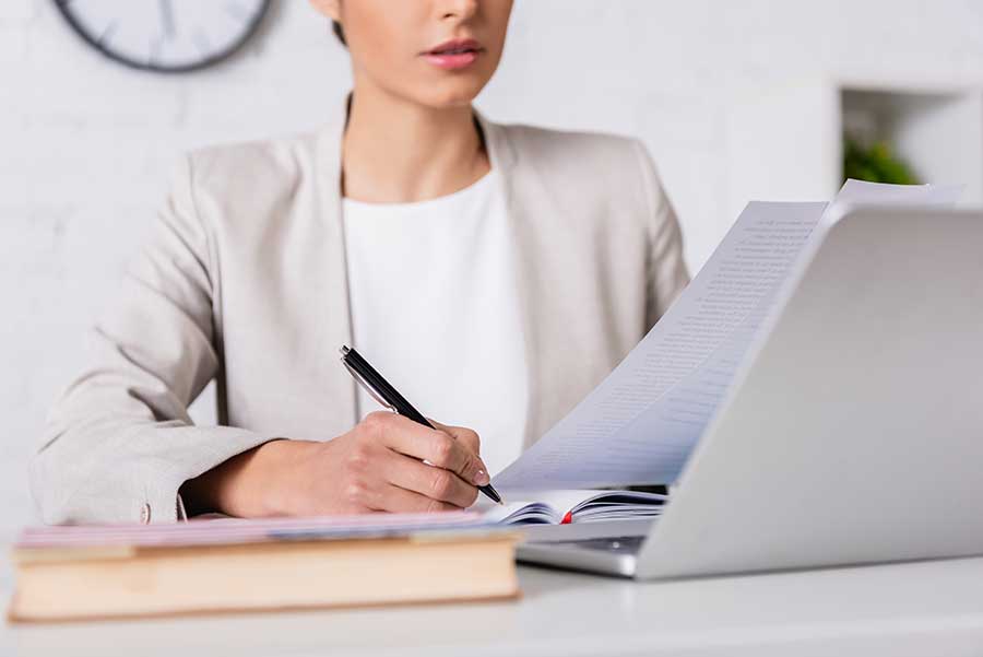 Femme d'affaires prenant des notes tout en parlant avec son traducteur multilingue.