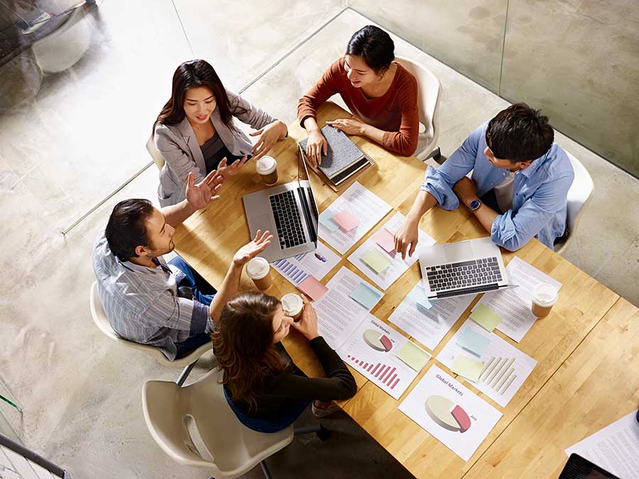 Japanese business meeting with documents and devices on the desk. Photo taken from above.