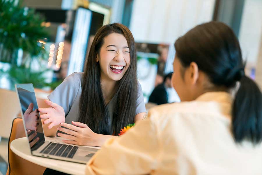 Traductrice japonaise professionnelle riant avec son client. 