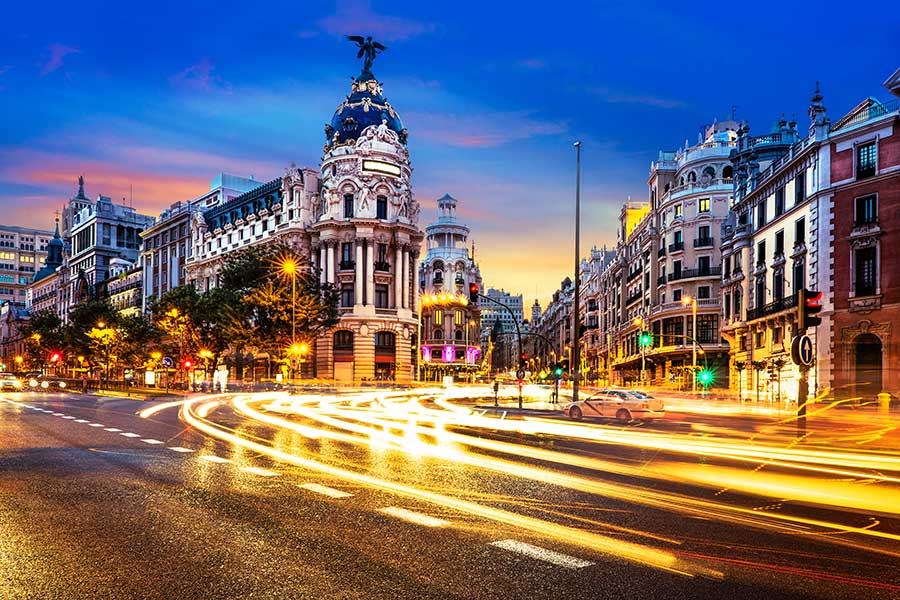 Spanish city at dusk with traffic lights passing by quickly.