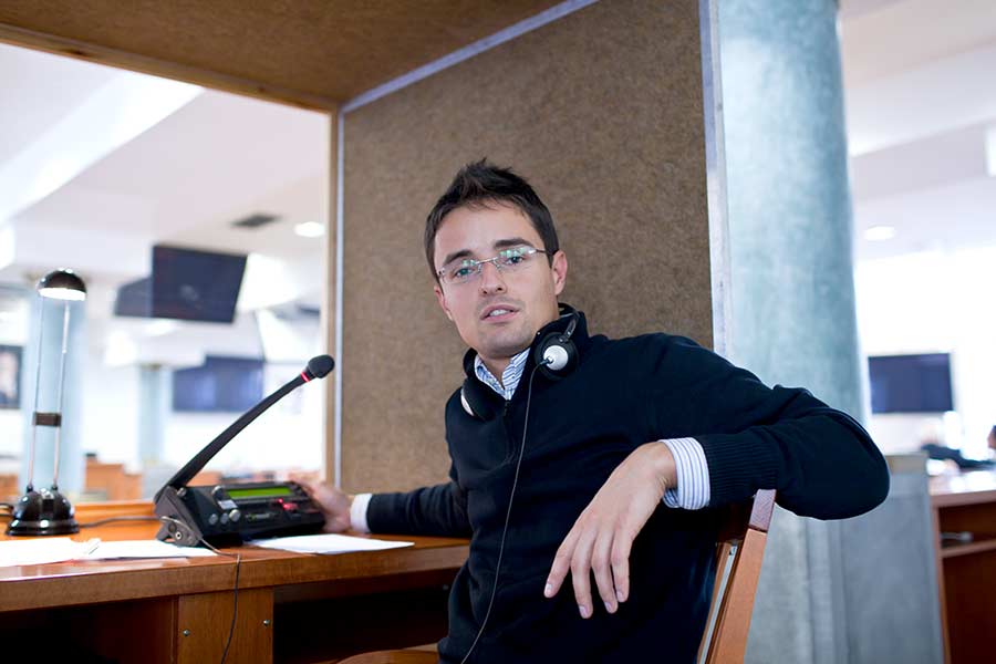 Homme avec des lunettes dans la cabine d’interprétation. 